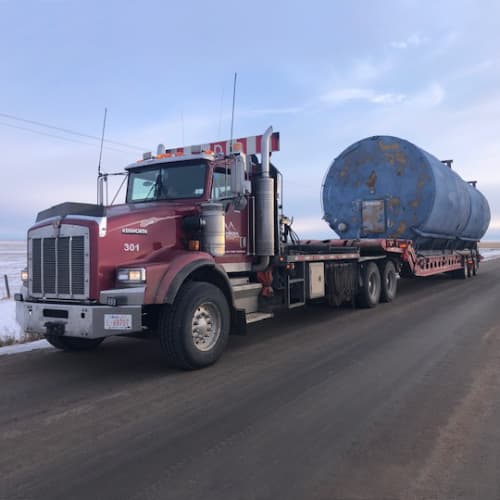 enviroex transporting 400 barrel tanks with tractor and texas trailer