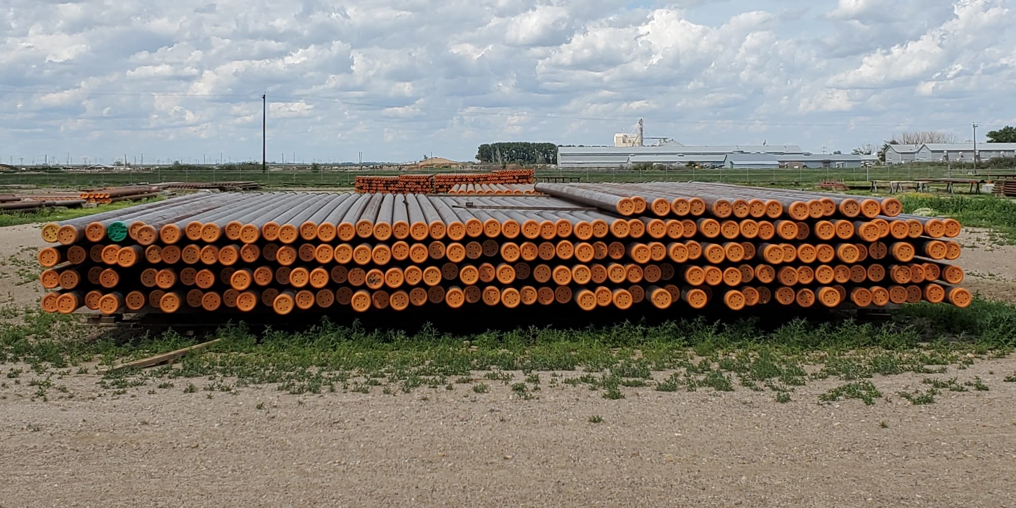stack of pipe within enviroex yard with orange caps